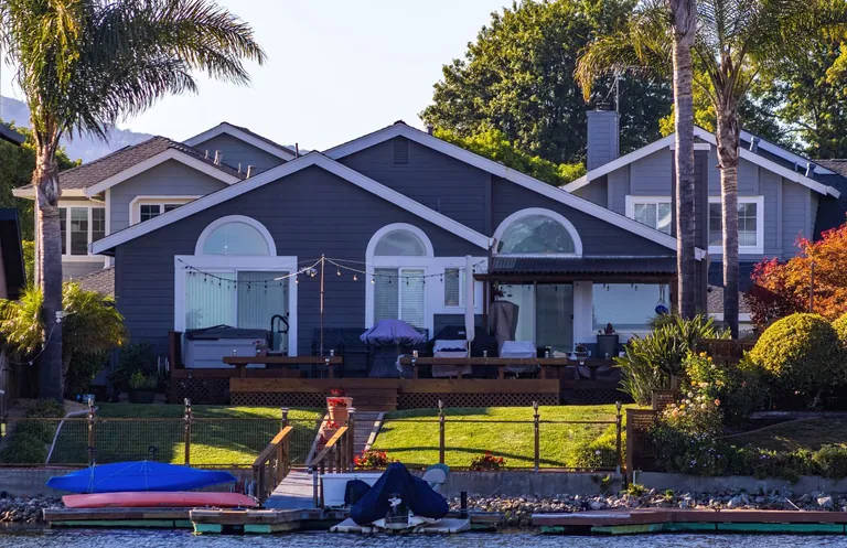 Coastal-style home with palm trees and outdoor living space